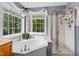 Well-lit bathroom features soaking tub, shower, and a bright window view at 2422 Castleburg Dr, Apex, NC 27523