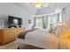Bright bedroom with large windows, tray ceiling, ceiling fan, and neutral decor at 2422 Castleburg Dr, Apex, NC 27523