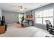 Spacious bonus room featuring neutral carpet, comfortable gray couch, and exercise equipment near bright windows at 2422 Castleburg Dr, Apex, NC 27523