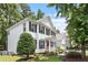 Beautiful two-story white home with landscaped yard, black shutters and a red front door at 2422 Castleburg Dr, Apex, NC 27523