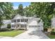 Charming two-story white home with black shutters, red door and attached two-car garage at 2422 Castleburg Dr, Apex, NC 27523