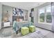 Modern bedroom with two large windows, gray carpet, and stylish green ottomans at 2602 Hitchcock Dr, Durham, NC 27705