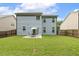 Expansive backyard featuring lush green grass, a patio set, and a secure wooden fence at 267 Dando St, Garner, NC 27529