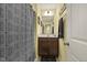Cozy bathroom with a framed mirror, vanity with storage, and patterned shower curtain at 267 Dando St, Garner, NC 27529