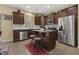 Kitchen with dark wood cabinets, tile backsplash, stainless appliances, and breakfast bar seating at 267 Dando St, Garner, NC 27529