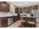 Kitchen featuring stainless appliances, tile backsplash, dark wood cabinets, and breakfast bar at 267 Dando St, Garner, NC 27529