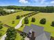 Picturesque estate with a long driveway, sprawling green lawns, and mature trees surrounding the charming brick home at 280 Phillips Rd, Selma, NC 27576