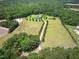 Aerial view of acreage featuring trees, grass, and a paved driveway leading to the home at 280 Phillips Rd, Selma, NC 27576