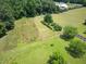 Aerial view of land featuring open fields, trees, and a residence in the distance at 280 Phillips Rd, Selma, NC 27576