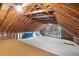 Unfinished attic space with exposed wooden beams and a window at 280 Phillips Rd, Selma, NC 27576