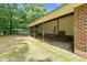 Backyard features a covered patio area adjacent to lawn with shade trees at 280 Phillips Rd, Selma, NC 27576