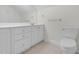 Clean bathroom with a white vanity, a sink, a large mirror, and neutral tiling at 280 Phillips Rd, Selma, NC 27576