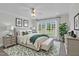 Staged primary bedroom featuring stylish furniture and a large window overlooking the yard at 280 Phillips Rd, Selma, NC 27576