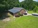 Aerial view of brick home with metal roof, large yard, and boat trailer in the driveway at 280 Phillips Rd, Selma, NC 27576