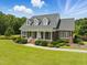 Inviting brick home featuring a charming front porch with classic columns and beautifully landscaped front yard at 280 Phillips Rd, Selma, NC 27576