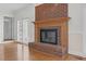 Close-up of the fireplace showcasing the brick surround, wooden mantle, and hardwood flooring at 280 Phillips Rd, Selma, NC 27576
