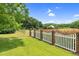 Spacious grassy yard is fenced in with wooden and brick fencing on a sunny day at 280 Phillips Rd, Selma, NC 27576