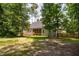 Rear view of home with screened porch, showcasing the spacious yard surrounded by trees and a wooden fence at 293 Carolina Oaks Ave, Smithfield, NC 27577