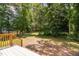 Expansive backyard view from a wooden deck, surrounded by mature trees and lush greenery at 293 Carolina Oaks Ave, Smithfield, NC 27577