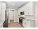 Well-lit kitchen boasts white cabinets, granite countertops, and stainless steel appliances at 293 Carolina Oaks Ave, Smithfield, NC 27577