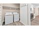 Convenient laundry room with washer, dryer, shelving, and easy access to the kitchen at 293 Carolina Oaks Ave, Smithfield, NC 27577