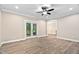 Open living room featuring hardwood floors, ceiling fan, and access to the backyard at 293 Carolina Oaks Ave, Smithfield, NC 27577