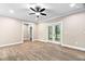 Bright living room featuring hardwood floors, ceiling fan, and French doors to a patio at 293 Carolina Oaks Ave, Smithfield, NC 27577