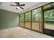 Cozy screened porch featuring a ceiling fan and a view of the wooded backyard at 293 Carolina Oaks Ave, Smithfield, NC 27577
