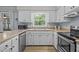 Kitchen features stainless steel appliances, white cabinets, and a window over the sink at 3007 Appling Way, Durham, NC 27703