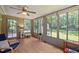Sunroom has many windows overlooking large backyard and an adjacent door to the outside, as well as laminate flooring at 3007 Appling Way, Durham, NC 27703