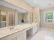 Bright bathroom with double sinks, vanity area, and a large mirror at 306 Neuse Ridge Dr, Clayton, NC 27527