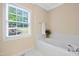 Clean, well-lit bathroom featuring a soaking tub and a large window at 306 Neuse Ridge Dr, Clayton, NC 27527