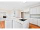 Open kitchen with island cooktop, granite counters, and white cabinets at 306 Neuse Ridge Dr, Clayton, NC 27527