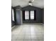 Spacious bedroom with vaulted ceilings, tile flooring, and large windows with blinds and drapes at 3129 Skycrest Dr, Raleigh, NC 27604