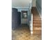 Entryway with hardwood floors, wooden staircase, blue accent wall, and framed mirror at 3129 Skycrest Dr, Raleigh, NC 27604