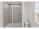 Bright bathroom featuring a glass shower, neutral tile, and white toilet at 319 Great Northern Station Sta, Apex, NC 27502
