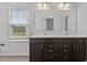 Bathroom with a double vanity, white countertop, and dark wood cabinets at 319 Great Northern Station Sta, Apex, NC 27502