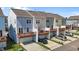 View of three-story townhomes featuring attached garages and second-story decks at 319 Great Northern Station Sta, Apex, NC 27502