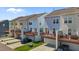 View of multi-colored townhomes featuring private garages and second-story decks at 319 Great Northern Station Sta, Apex, NC 27502