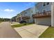 View of multi-colored townhomes featuring private garages and second-story decks at 319 Great Northern Station Sta, Apex, NC 27502