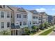 New row of three-story townhomes with multi-pane windows and beautifully landscaped yards at 319 Great Northern Station Sta, Apex, NC 27502