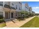 Townhome row with blue siding and manicured front lawns and walkways at 319 Great Northern Station Sta, Apex, NC 27502