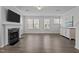Bright living room features a fireplace, mounted TV, hardwood floors and large windows at 319 Great Northern Station Sta, Apex, NC 27502