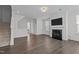 Cozy living room with a fireplace, mounted TV, staircase and hardwood floors at 319 Great Northern Station Sta, Apex, NC 27502