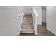 Carpeted staircase with white railing and neutral walls leading to the upper level of the home at 319 Great Northern Station Sta, Apex, NC 27502
