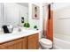 A clean, tiled bathroom features a vanity with a sink, toilet, shower with curtain and artwork at 320 Gilman Ln # 106, Raleigh, NC 27610
