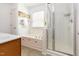 Bright, white-tiled bathroom featuring jetted tub, glass-enclosed shower, and a vanity with ample counter space at 320 Gilman Ln # 106, Raleigh, NC 27610