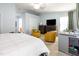 Bright bedroom featuring neutral walls, ceiling fan, and reading area with two comfortable yellow chairs at 320 Gilman Ln # 106, Raleigh, NC 27610