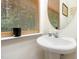 Charming half bathroom featuring a pedestal sink, oval mirror and wood blinds at 320 Gilman Ln # 106, Raleigh, NC 27610