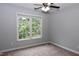 Bedroom with neutral walls and carpet boasts a ceiling fan and natural light at 3209 Leebrook Rd, Raleigh, NC 27616